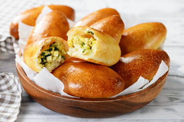 Freshly baked patties ( russian piroshki ) with egg and green onion stuffing.