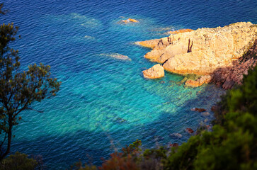A cove with a rugged rock shoreline and clear blue water. 