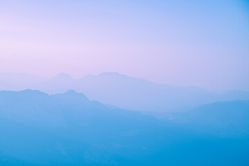 Silhouettes of mountains in a beautiful gentle haze, mountains at sunset or sunrise, natural background