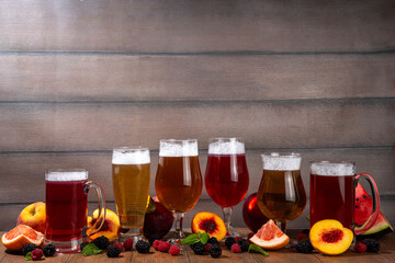 Set of fruit and berry beer ales drinks, cider or beer shandy cocktails with various sweet taste, with fresh fruit and berry assortment 
