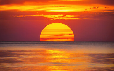 Vibrant Sunset Over Calm Ocean Waters With Warm Colors and Clouds at Dusk