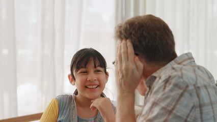 Grandfather and granddaughter together talking about entertainment media on TV. Old senior use conversation communicate with young generation cross generation gap strengthen family bond. Divergence.
