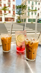 Refreshments including iced coffee and a lime soda served on a tray outdoors during a sunny day in an urban setting