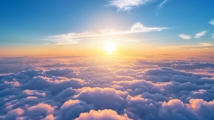 Sunrise in a blue sky with scattered clouds. A view above the clouds.