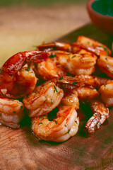 fried tiger prawns, jumbo, in garlic sauce, in butter, with herbs, on a wooden board, homemade, no people,