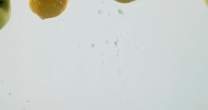 Fruit, mix and vitamin c with water splash in natural nutrition, fresh produce or hydration in studio on a white background. Closeup of apple, lemon or citric acid of wet organic food in healthy diet