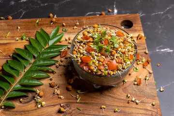Healthy Vegan Sprout Salad Recipe with Fresh Tomatoes and Lemon on a Rustic Wooden Board