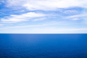 Background of blue sky over ocean. The far away horizontal line seperates between sky and ocean. It is calm and serenity. Good ideas for designing backdrops, background to celebrate new season, party