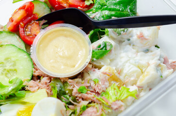 A salad with a black spoon and a yellow sauce