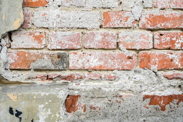 Old masonry wall made of red bricks with crumbled plaster as full frame background structure for architecture and construction themes, copy space