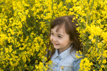 a little girl in a field of flowering yellow. field. girl with yellow flowers