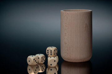 drewniane kości do gry i kubek do kości jako symbol hazardu © Henryk Niestrój