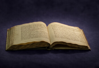 stara księga otwarta, rękopiśmienna na ciemnym tle