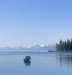 Boat on Lake Tahoe with snow covered mountains in the background