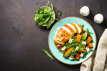 Warm salad with baked chicken breast, pumpkin, blue cheese and arugula. Dash diet, keto diet meal....