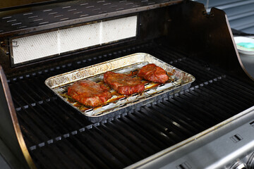 Several fresh and juicy pieces of steak with spicy spices on the grill