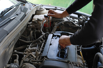 Obraz premium Auto mechanic installs ignition in car, auto repair