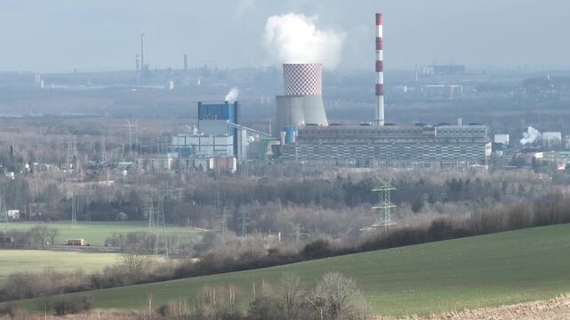 Aerial drone view of the chimneys of a coal fired power plant.Large chimneys of the power plant cooling tower. Drone flight past the power plant. Industrial Power plant in Bedzin, Poland.