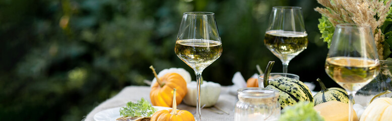 Fall still-life. Orange pumpkins, dry flowers and candles on linen tablecloth. Dinner table...