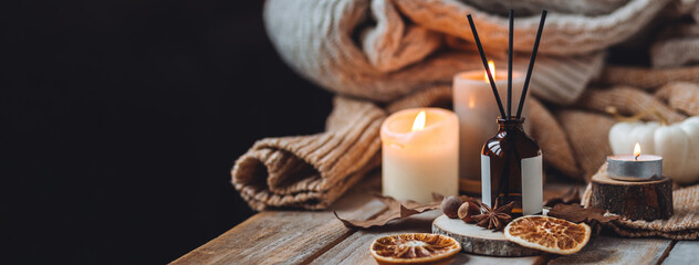 Home comfort, coziness, aromatherapy. Cozy interior with knitting, burning candles and aroma...