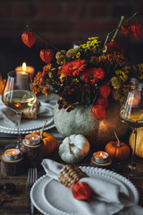 Fall table decoration with pumpkins, wine. Family cozy thanksgiving dinner arrangement indoors at home, wedding elegant decor. Countryside style, simple handmade setting, autumn mood, inspiration.