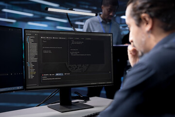 IT specialist reconfiguring server room to optimize it for data processing requirements of...
