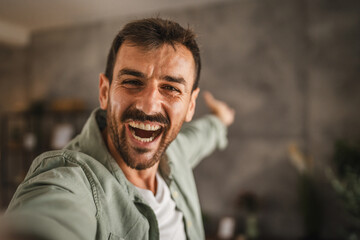 self portrait of adult excited man stand and smile at home