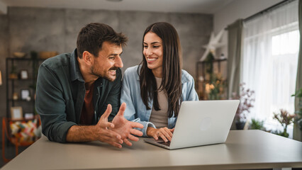 adult caucasian couple stand and use, study learn on laptop at home