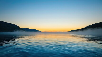 Obraz premium Sunrise Over Misty Lake Surrounded by Mountains With Tranquil Waters Reflecting the Colors of Dawn