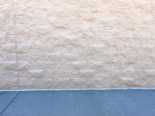 Fototapeta premium Beige Brick Wall with Clean Concrete Sidewalk