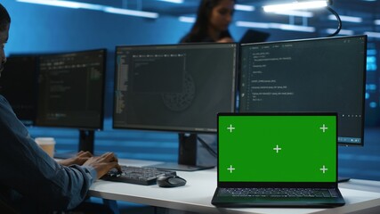 Expert in server hub workspace using isolated screen PC monitor to repair devices storing datasets. Technician using chroma key computer to do servicing on rigs doing computational operations