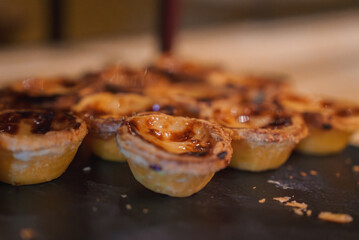 A tray of Portuguese custard tarts, Pasteis de Nata, with flaky crusts and caramelized tops, highlighting the luxury hotels attention to detail and quality.