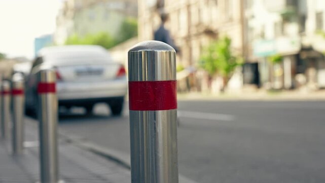 central part the city roadway with different foreign cars focus on asphalt traffic of cars sunny weather iron bollards limiter for cars