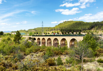 Fototapeta premium Railroad bridge near Mudejar Highway A-23 in Segorbe and Soneixa, Sot de Ferrer, Castellon Province, Valencian Community, Spain. View from Ojos Negros Greenway. Stone rail bridge. Old bridge.