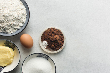 Overhead view of ingredients for making chocolate cookies, top view of mise en place of ingredients for making chocolate sugar cookies, process of making chocolate cookies