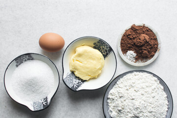 Overhead view of ingredients for making chocolate cookies, top view of mise en place of ingredients for making chocolate sugar cookies, process of making chocolate cookies