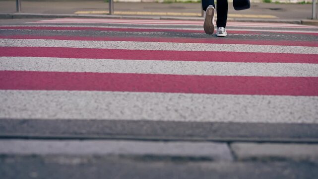 on road pedestrian crossing red and white stripes close-up of legs in white beauties crossing the road safe movement