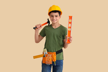 Little architect with hammer and level on beige background