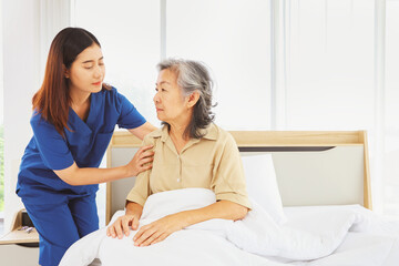 Female doctor nurse take care elderly female patient who is being treated for discomfort due congenital disease gently supporting her shoulder to help her sleep : Elderly health insurance.