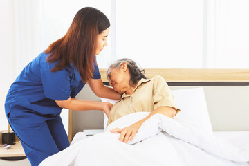 Fototapeta premium Female doctor nurse take care elderly female patient who is being treated for discomfort due congenital disease gently supporting her shoulder to help her sleep : Elderly health insurance.