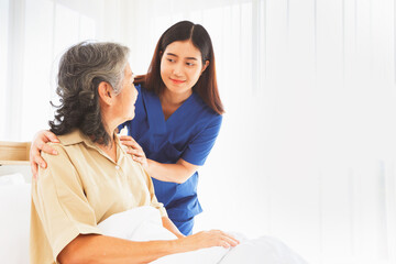 Fototapeta premium Female doctor nurse take care elderly female patient who is being treated for discomfort due congenital disease gently supporting her shoulder to help her sleep : Elderly health insurance.