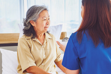 Obraz premium Caring for elderly patients : Female doctor nurse caring for elderly patients paying attention to nutrition preparing breakfast with porridge or soup for rehabilitation health and treatment at home.