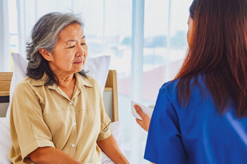 Caring for elderly patients : Female doctor nurse caring for elderly patients paying attention to nutrition preparing breakfast with porridge or soup for rehabilitation health and treatment at home.