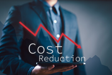 Businessman working on company cost saving. Cost wording on decreasing coins stacking with the down arrow. Cost Management, Economy recession, low budget, Effective business, Cost reduction concept.
