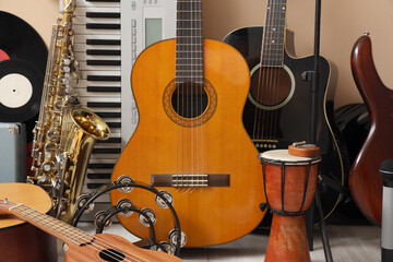 Different musical instruments near beige wall, closeup
