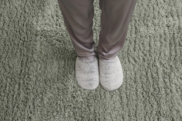 Woman in slippers standing on soft carpet. New beginning concept