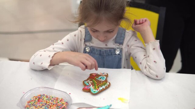 A Child Joyfully Decorating a Gingerbread Cookie w