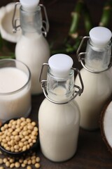 Different types of vegan milk and ingredients on wooden table