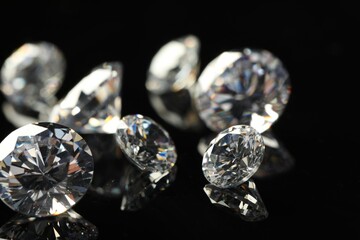 Many beautiful shiny diamonds on black mirror surface, closeup