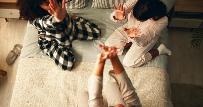 Above, bedroom and friends with huddle at night for support, care and trust on sleepover. People, relationship and happy or laugh at home with bonding session or girls time for love, break and relax